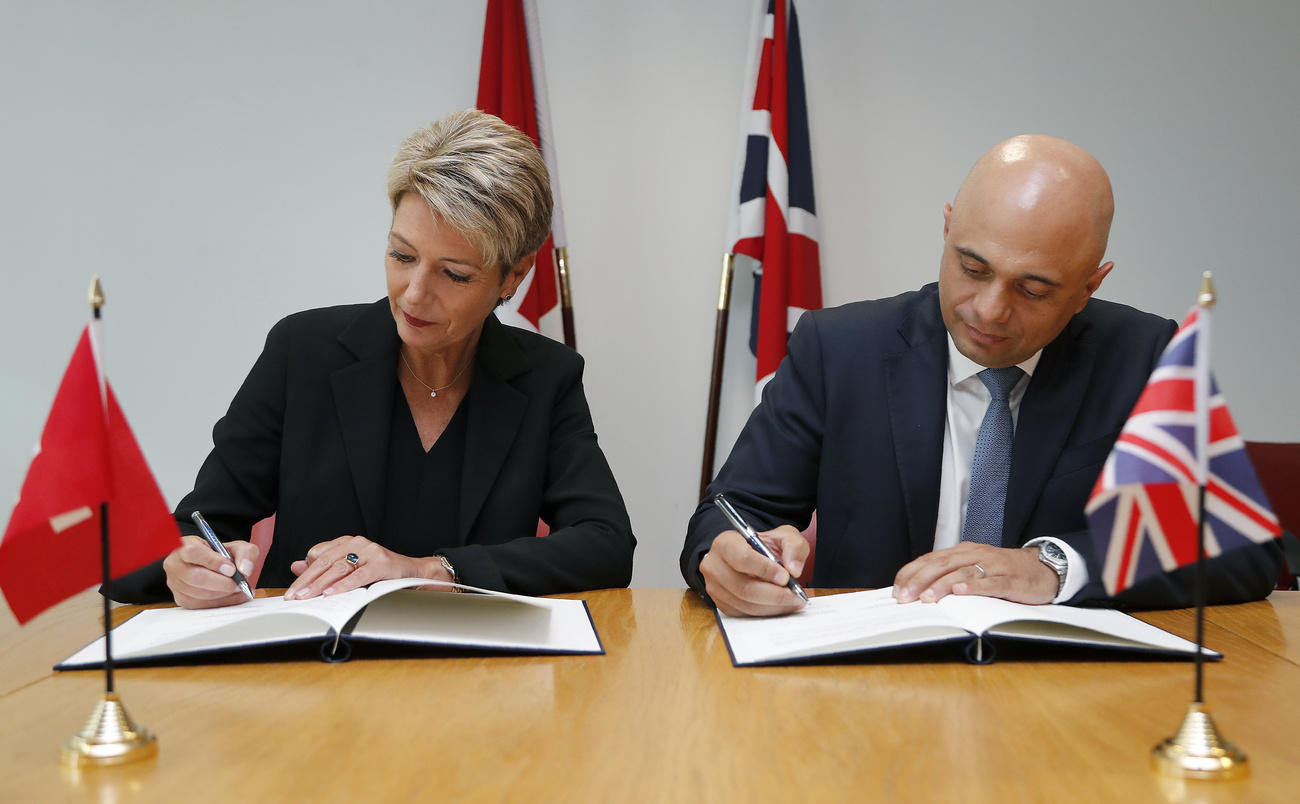 Karin Keller Sutter and British Home Secretary Sajid Javid sign a contract