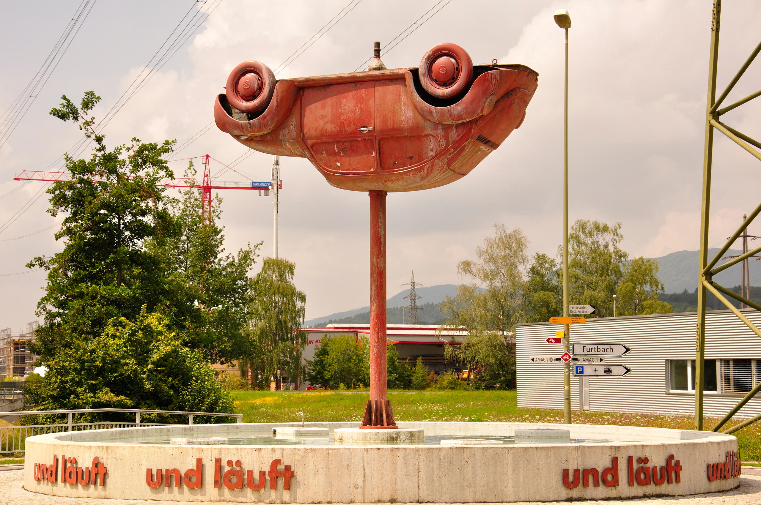 An upside down car on a pole.