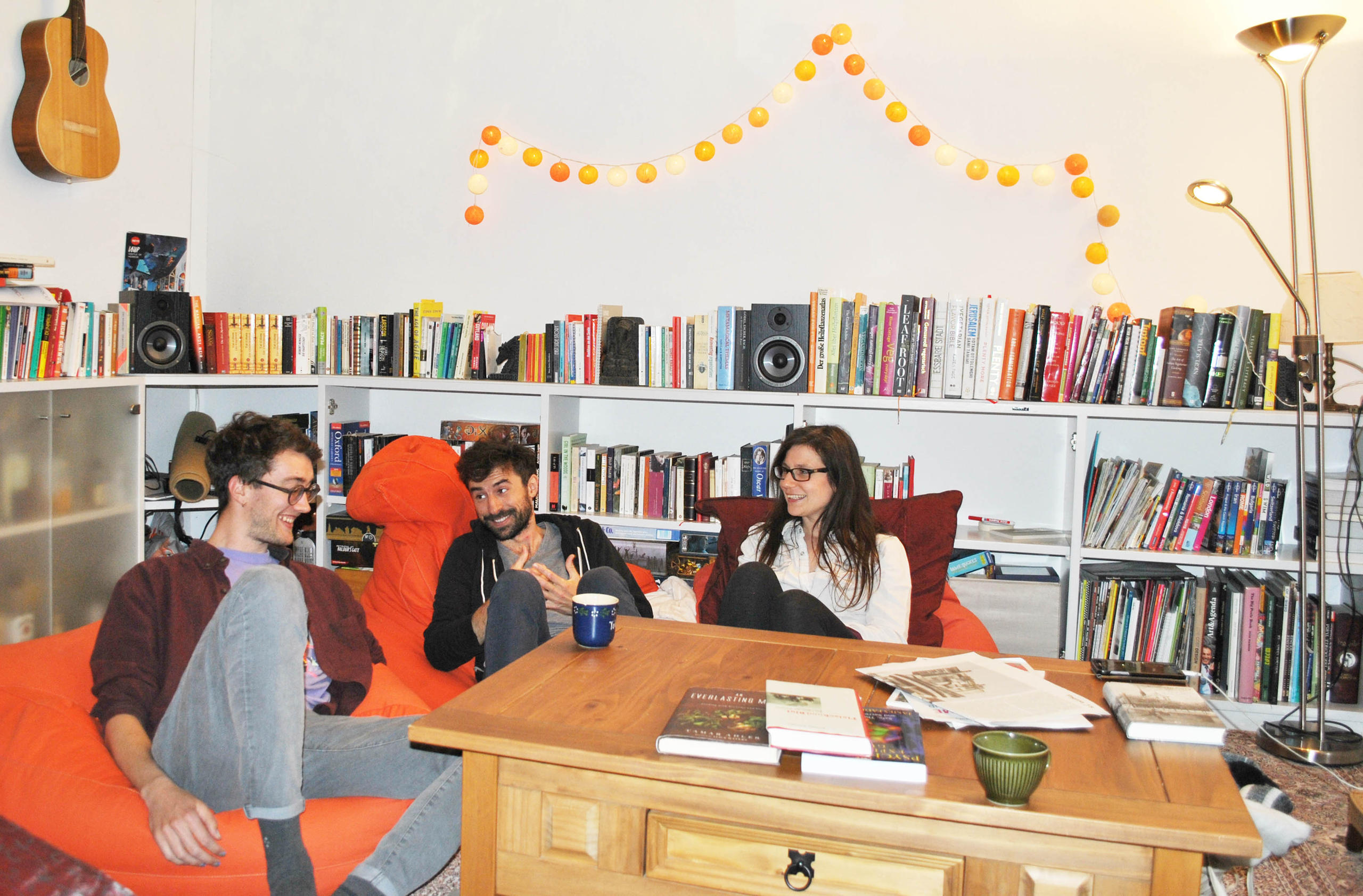 Trois jeunes gens assis à une table dans un appartement