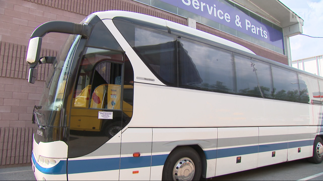 Pullman bianco una striscia blu ritratto di traverso dall angolo del posto di guida; dietro, officina