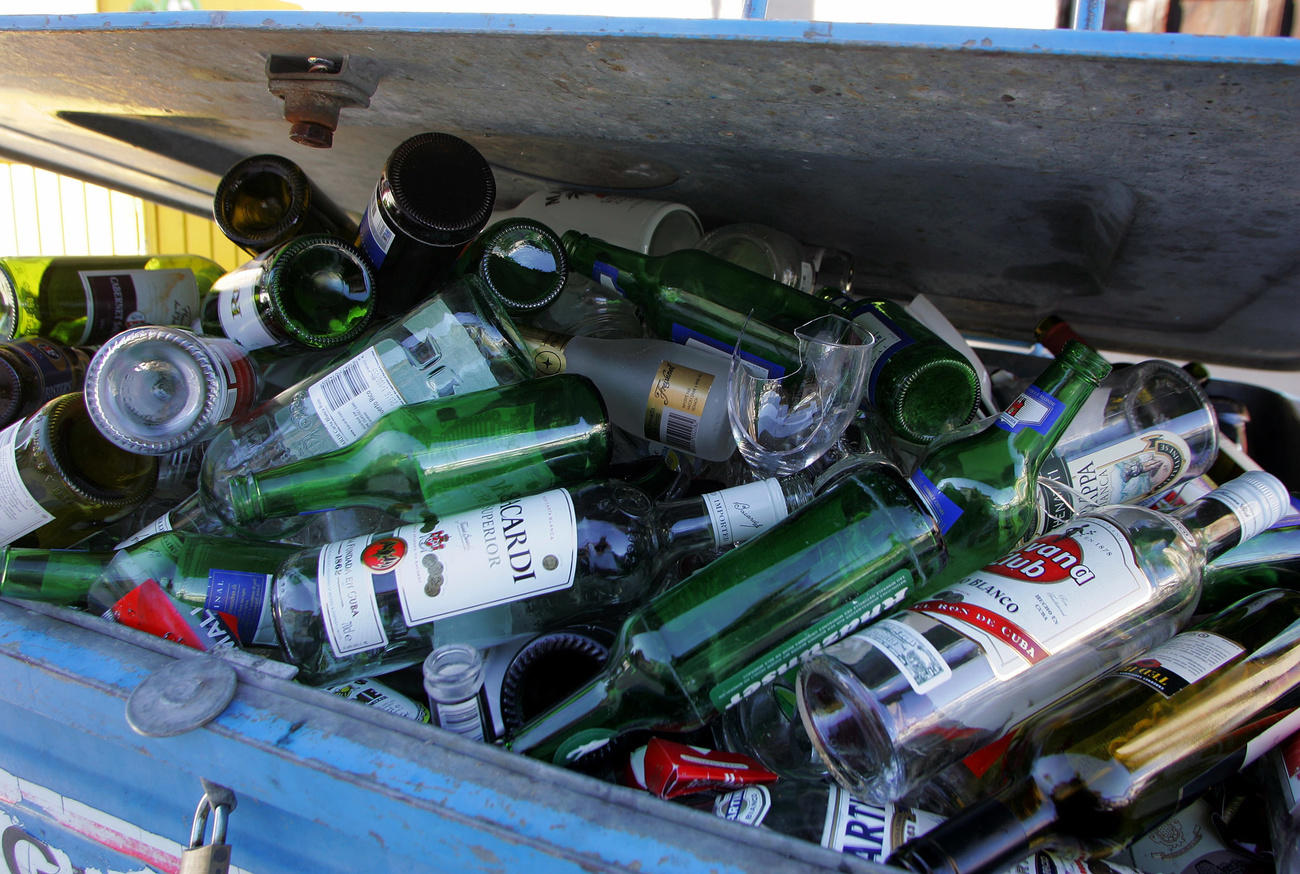 Bottiglie di vetro in un ammassate in un contenitore per il riciclaggio