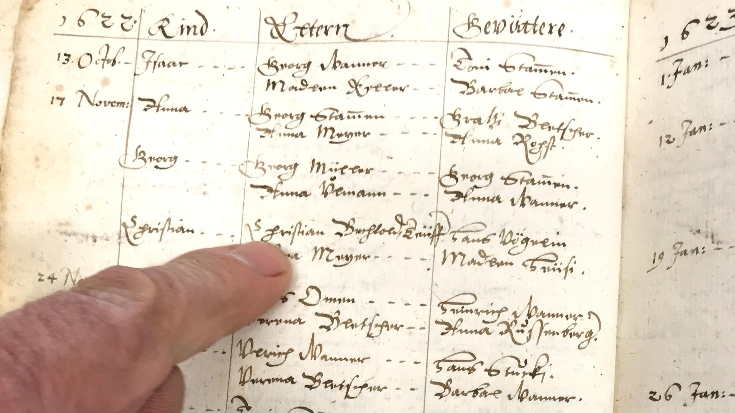 Finger points to Old German script entry in archive record