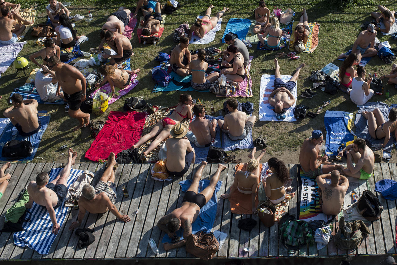 People in swimsuits enjoy the hot weather at a Zurich park in June 2015