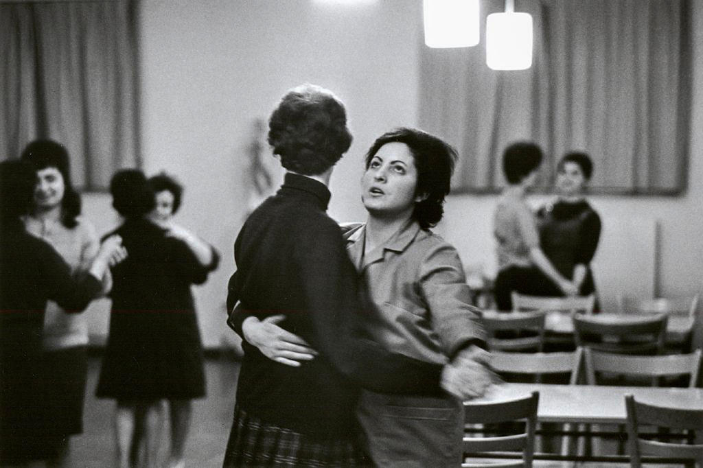 A woman dancers with her partner and looks up to the ceiling.