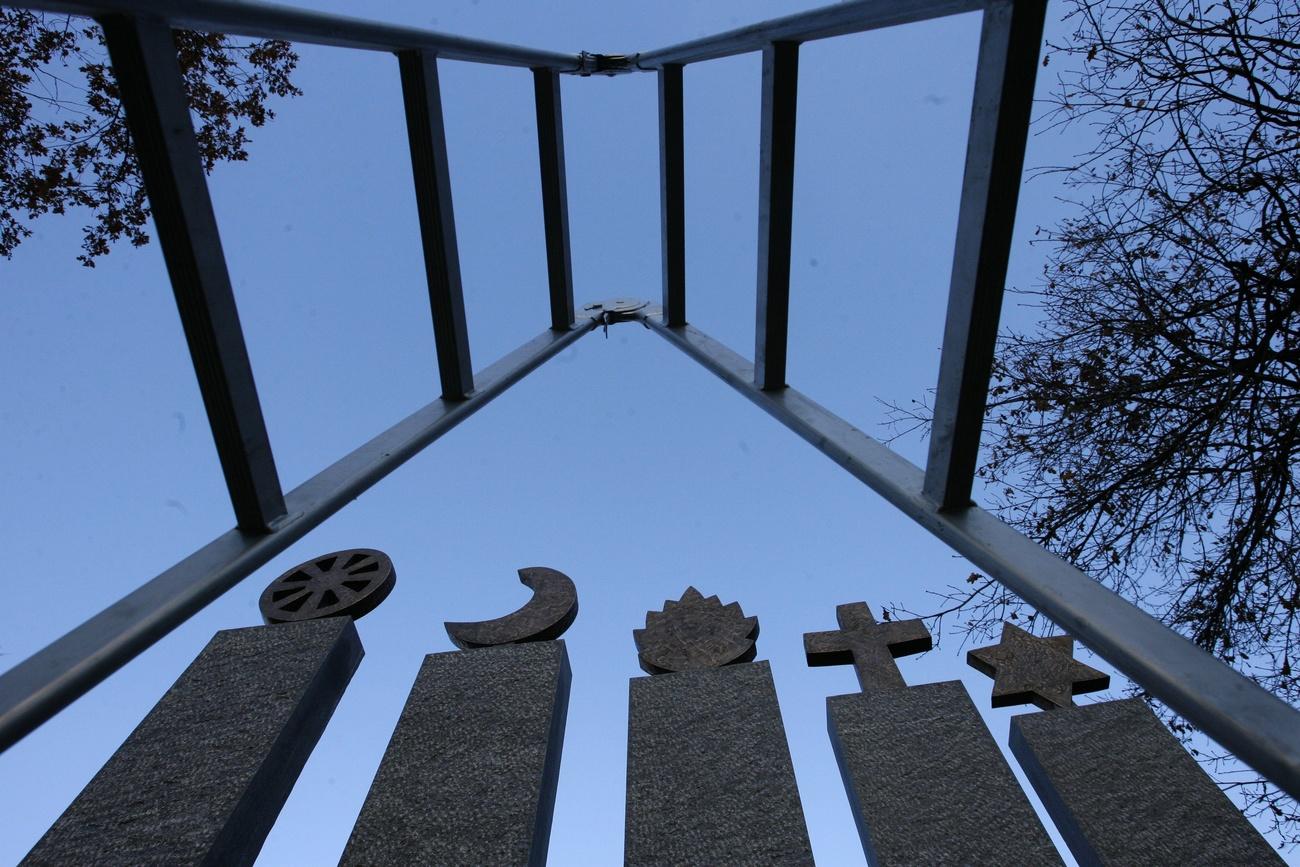 Simboli di cinque religioni (ebraismo, cristianesimo, induismo, islam e buddhismo) in un monumento cimiteriale