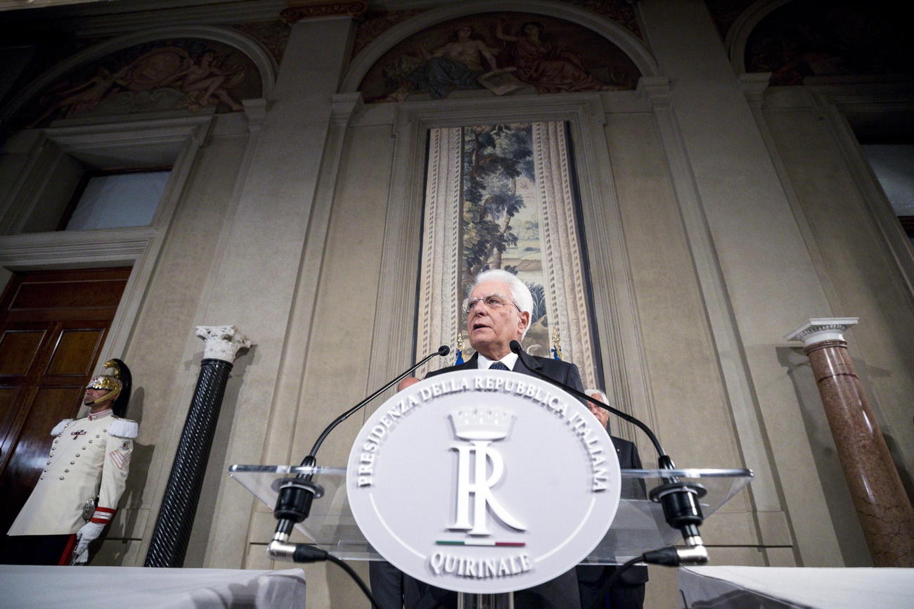 Il presidente italiano al suo pulpito al Quirinale fotografato dal basso; si vedono colonne e arredi del palazzo