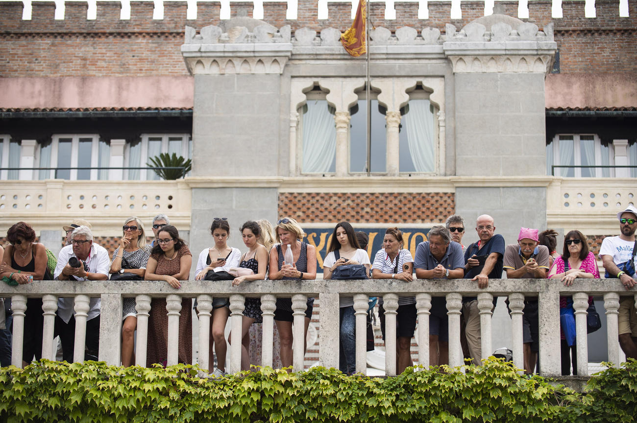 gente affacciata su un balcone veneziano