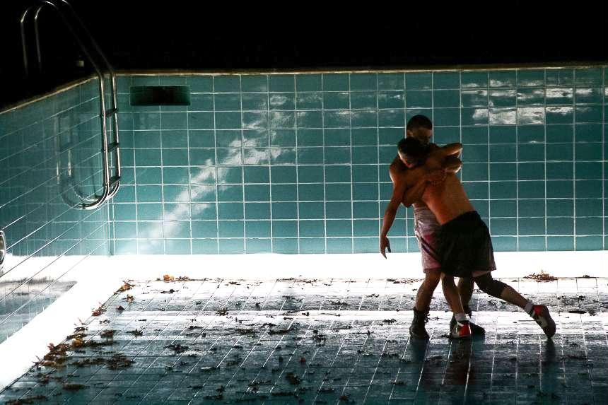 Two men fighting in an empty pool