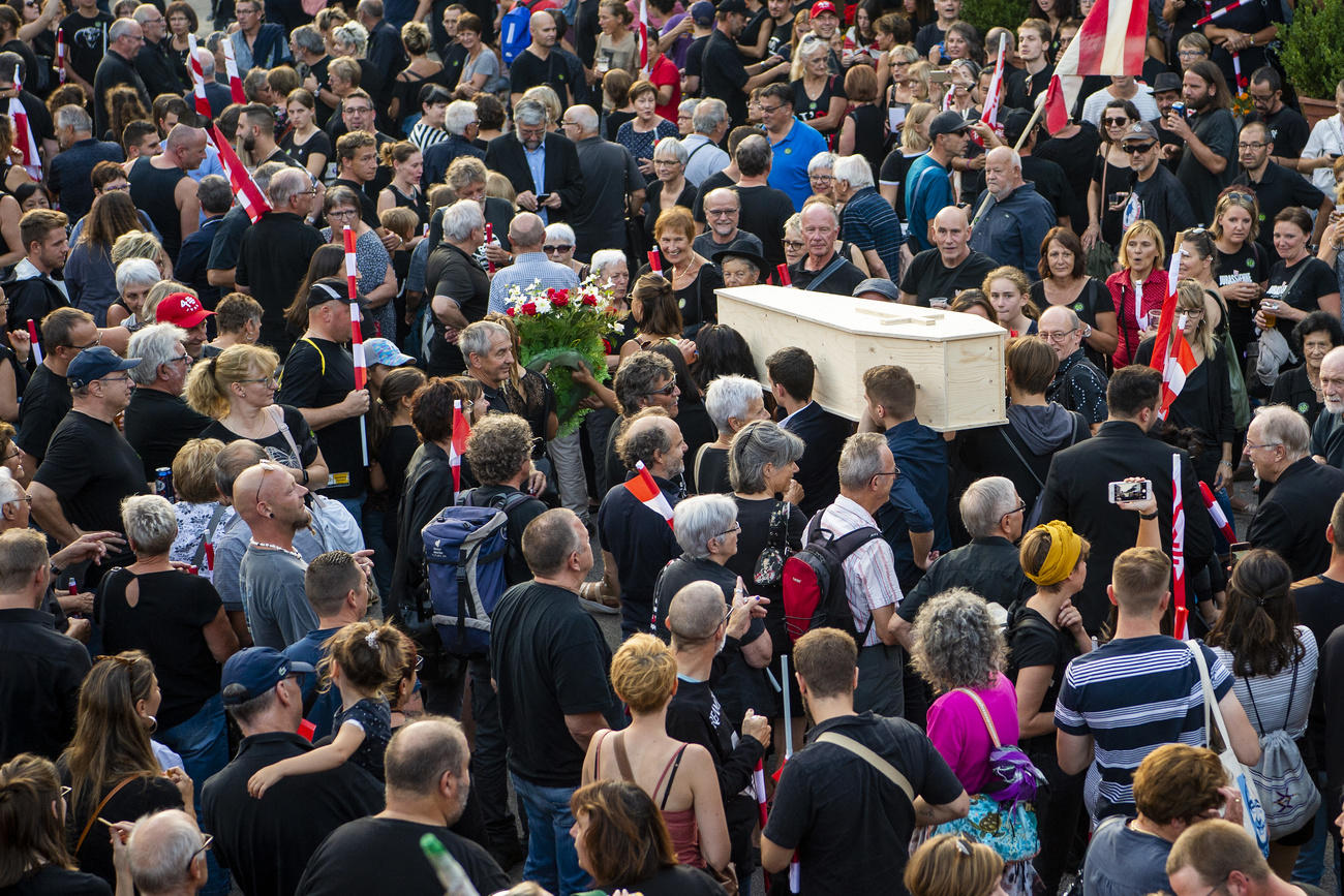 Protesters carry a coffin down a street