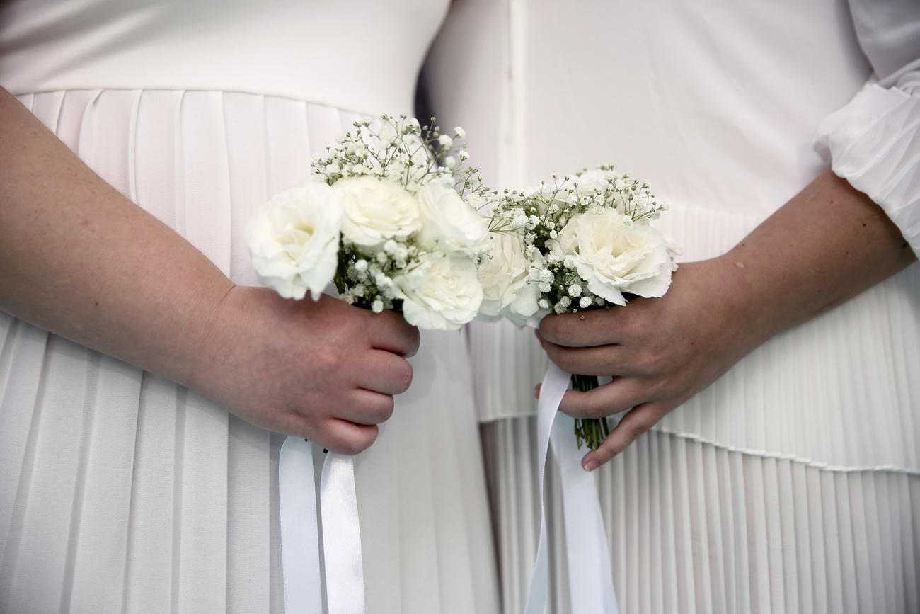 Donne unite in matrimonio che mostrano il bouquet di fiori.