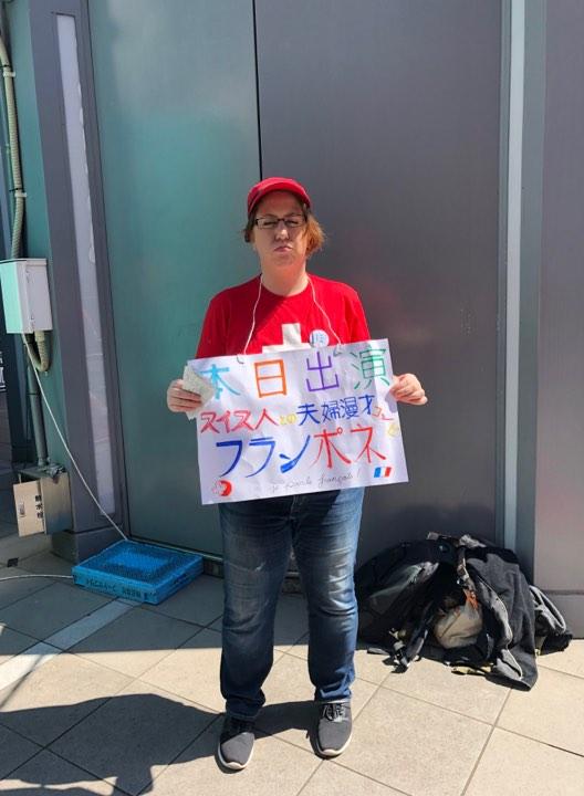 フリップを掲げて路上に立つ女性