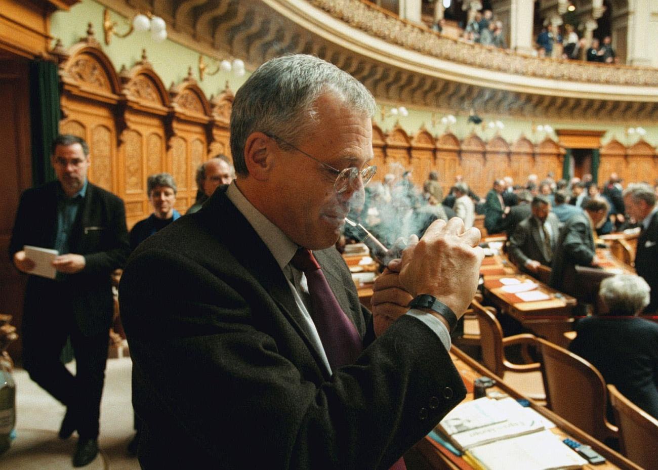Un hombre enciende una pipa en el interior del Parlamento.