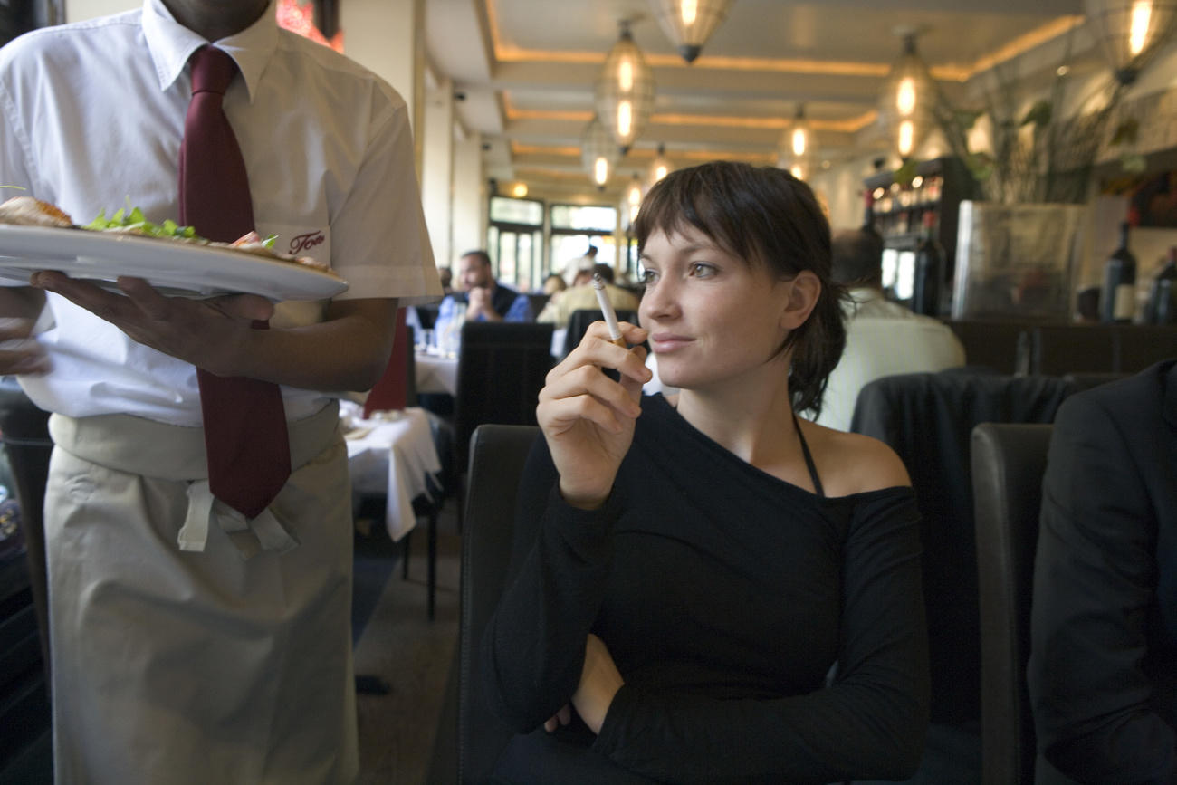 Une jeune femme fume dans un restaurant