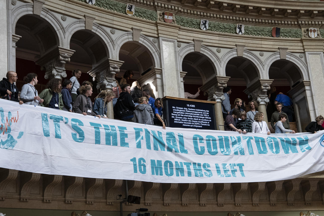 persone srotolano uno striscione