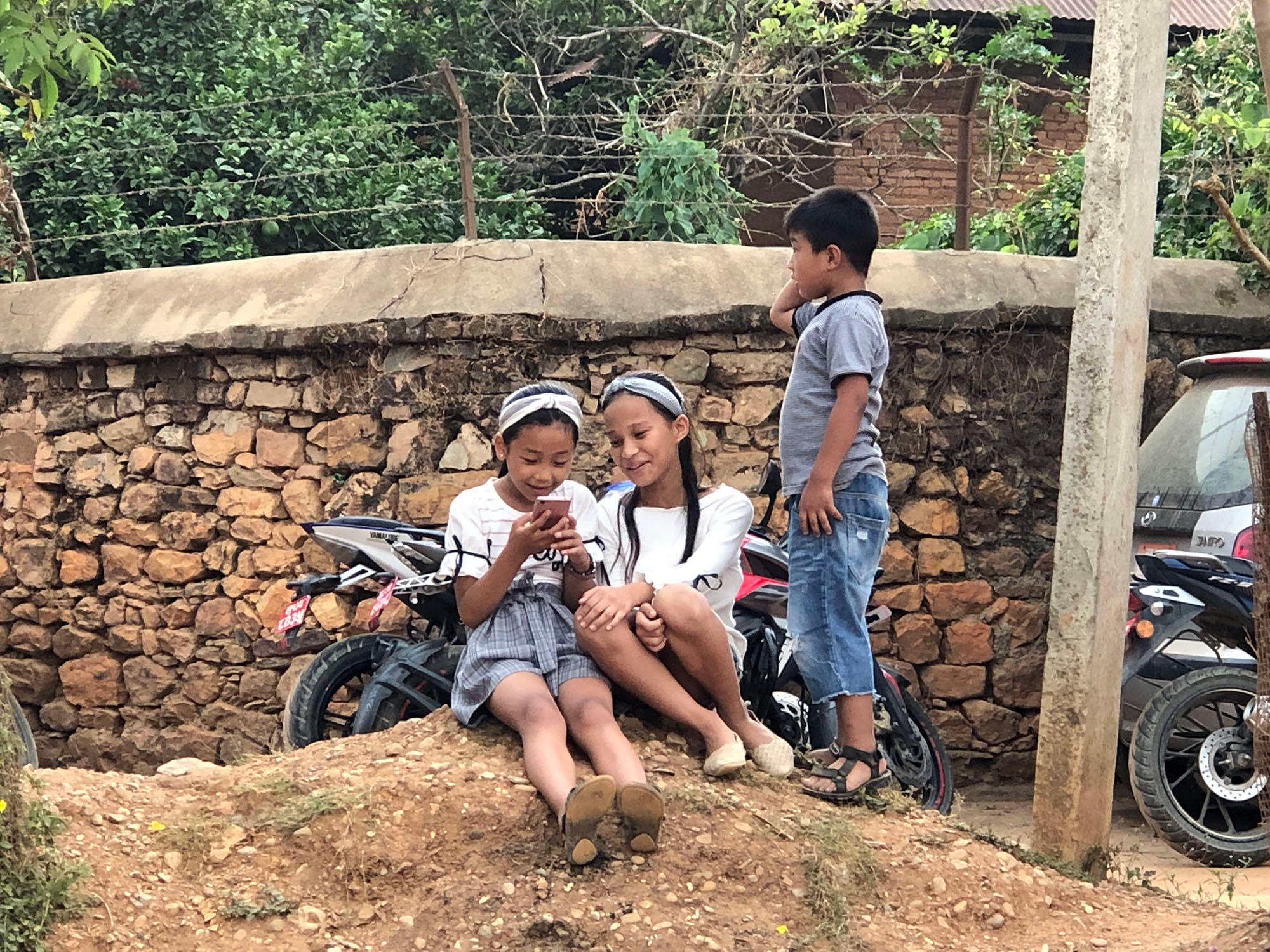 bambini con telefoni cellulari