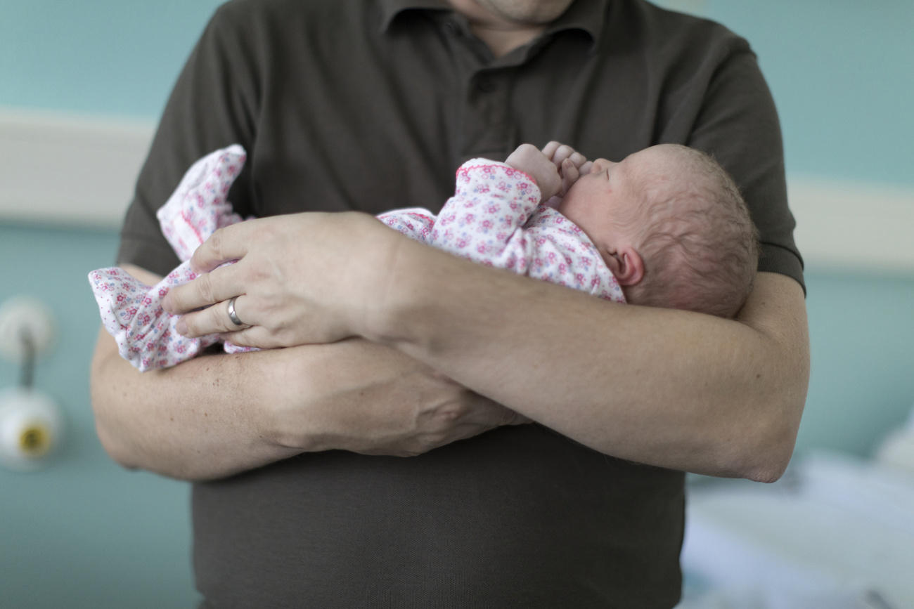 Man holding a newborn baby in his arms