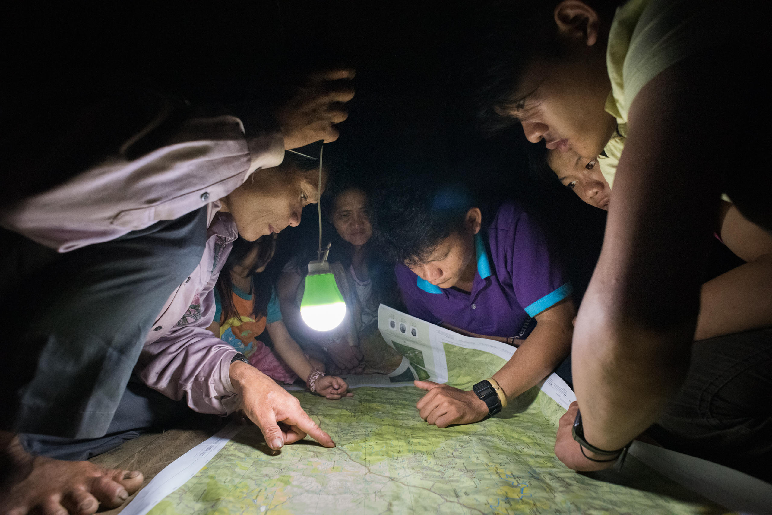 gente che consulta una mappa alla luce di una lampadina