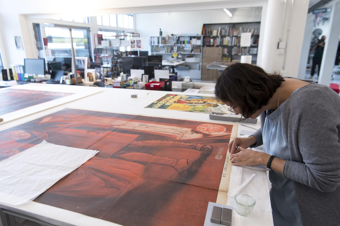 A specialist restores a poster at the Penthaz centre