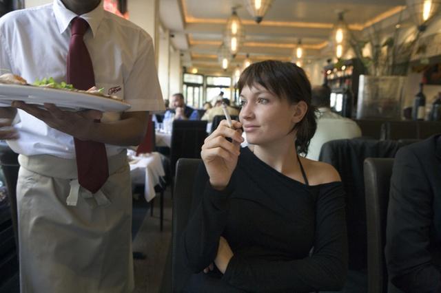 Une femme avec une cigarette dans un restaurant