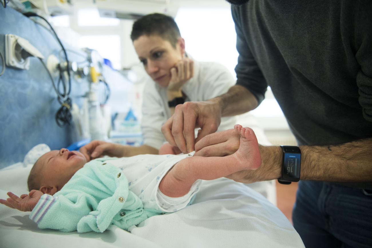 Una uomo mentre sta cambiando un neonato ancora all ospedale
