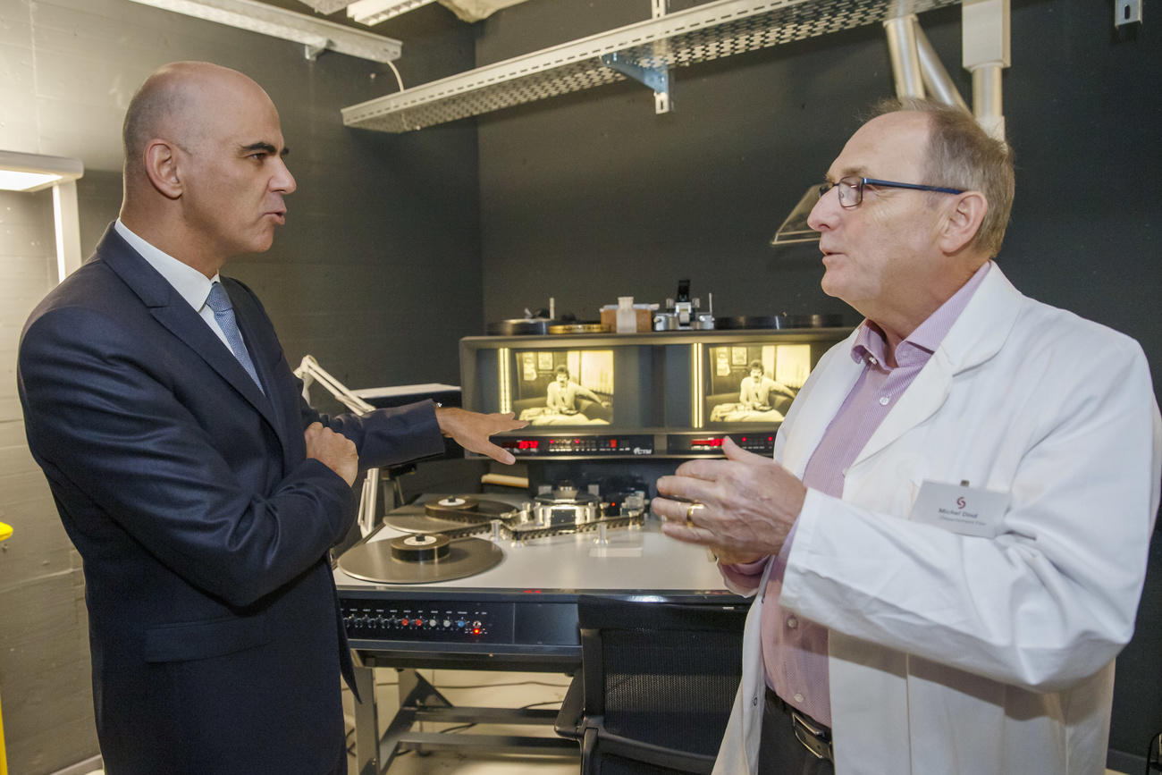 Interior Minister Alain Berset talks to a technician at the Penthaz centre