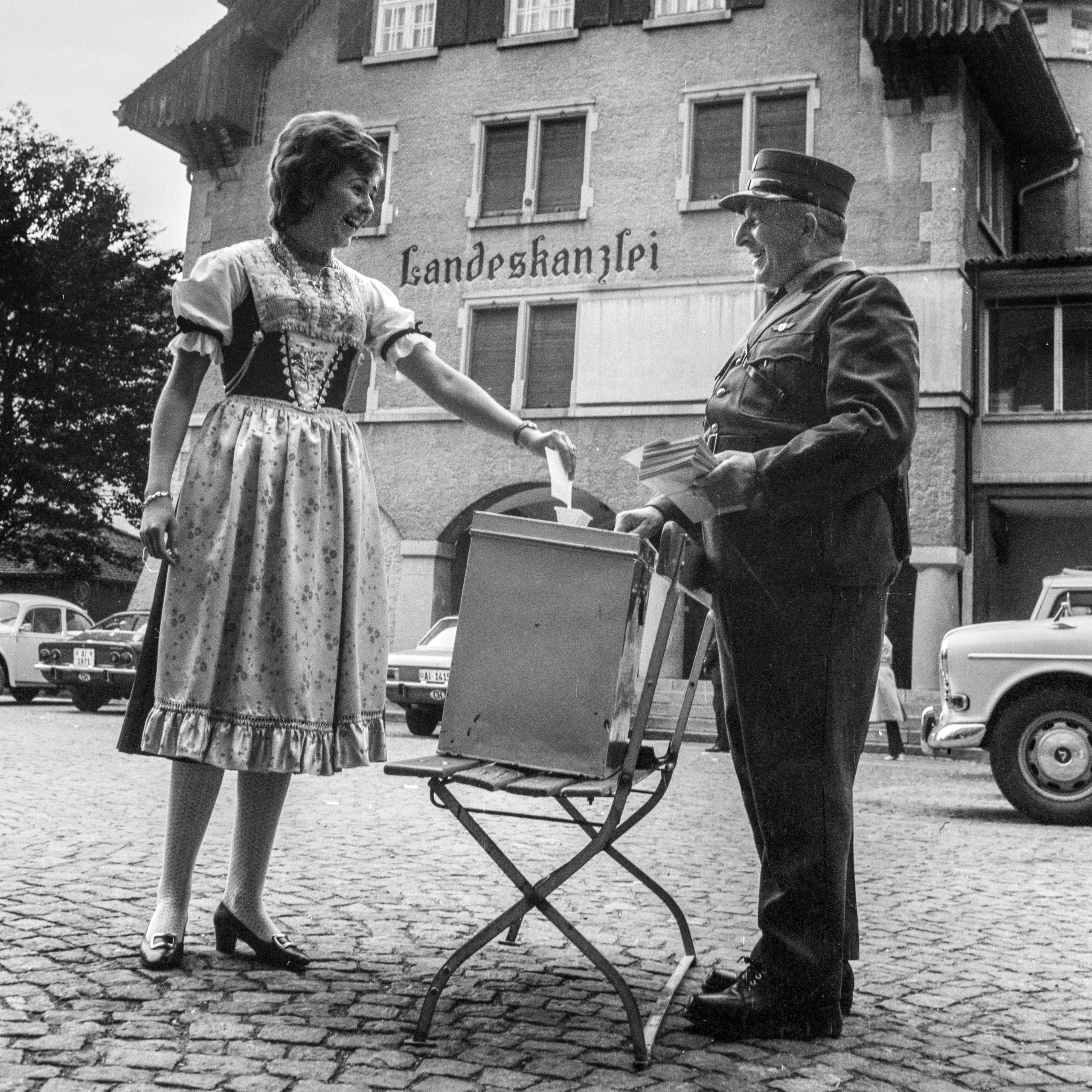 Une femme en costume traditionnel en train de voter.