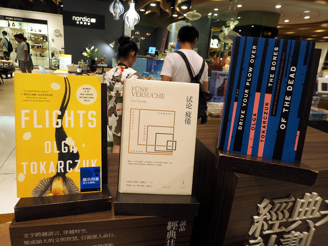 Primo piano di un espositore di libri in un negozio con insegne in ideogrammi cinesi tradizionali