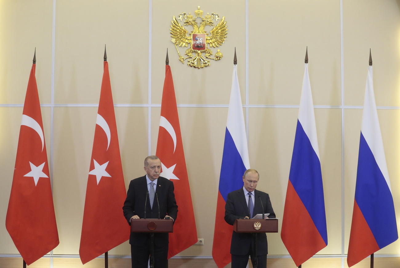 Erdogan and Putin auf einem Podium vor den Flaggen ihrer Länder.
