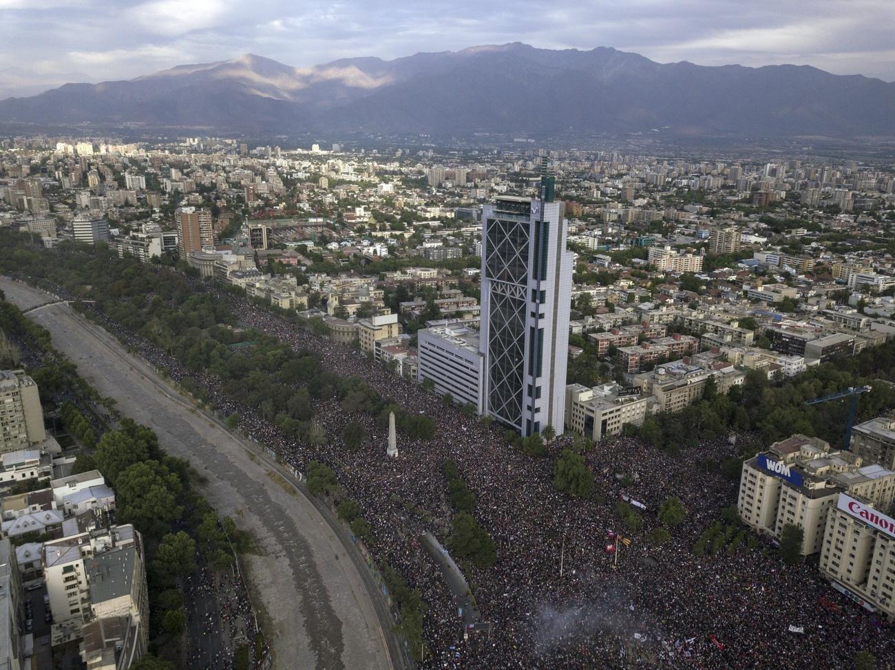 Veduta aerea di un grande viale di metropoli, completamente occupato da persone; non si vede l asfalto