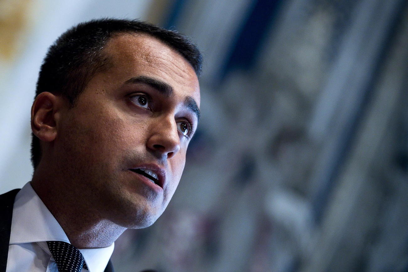 Primo piano del volto di Luigi DI Maio; fondo sfuocato; si intuisce che si tratta di un vecchio palazzo