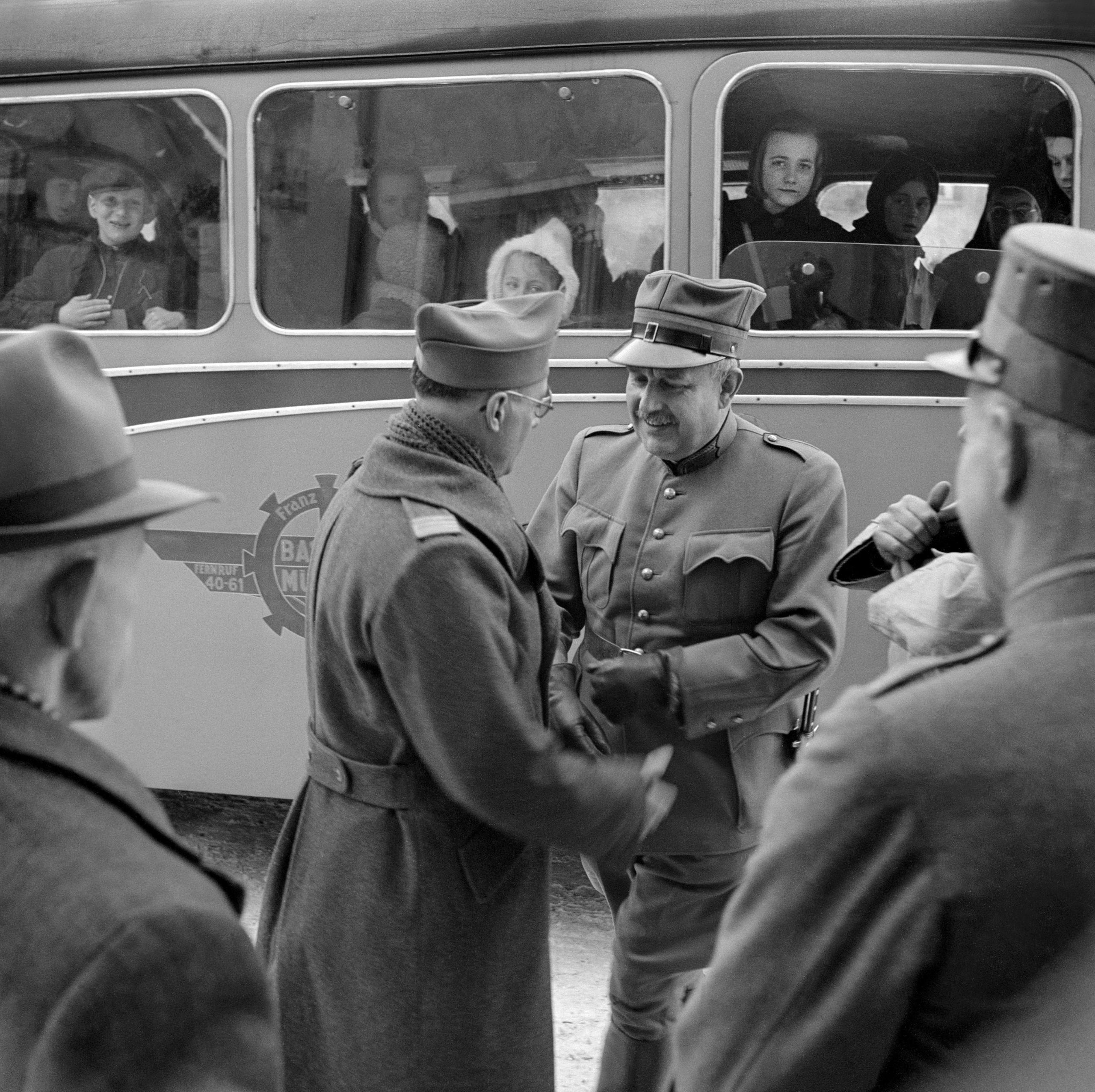 Soldados junto a un autobús con niños en su interior.