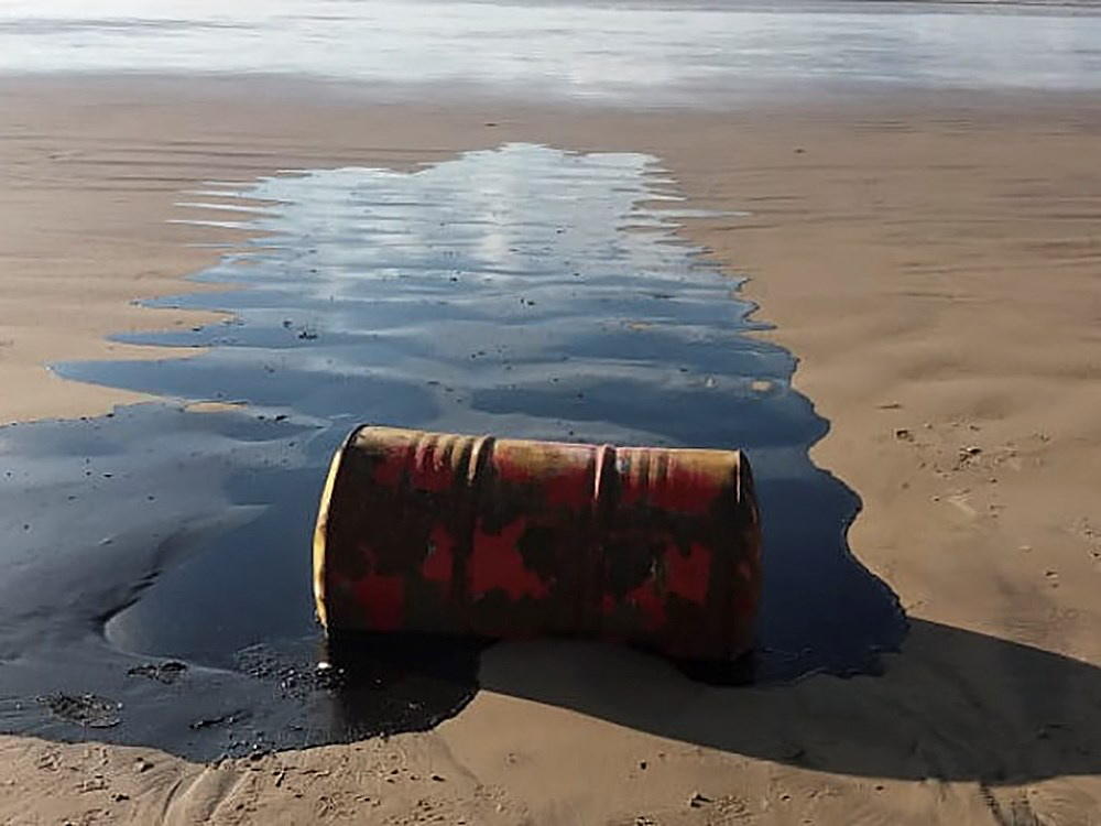 barril de petróleo vazando numa praia de Sergipe