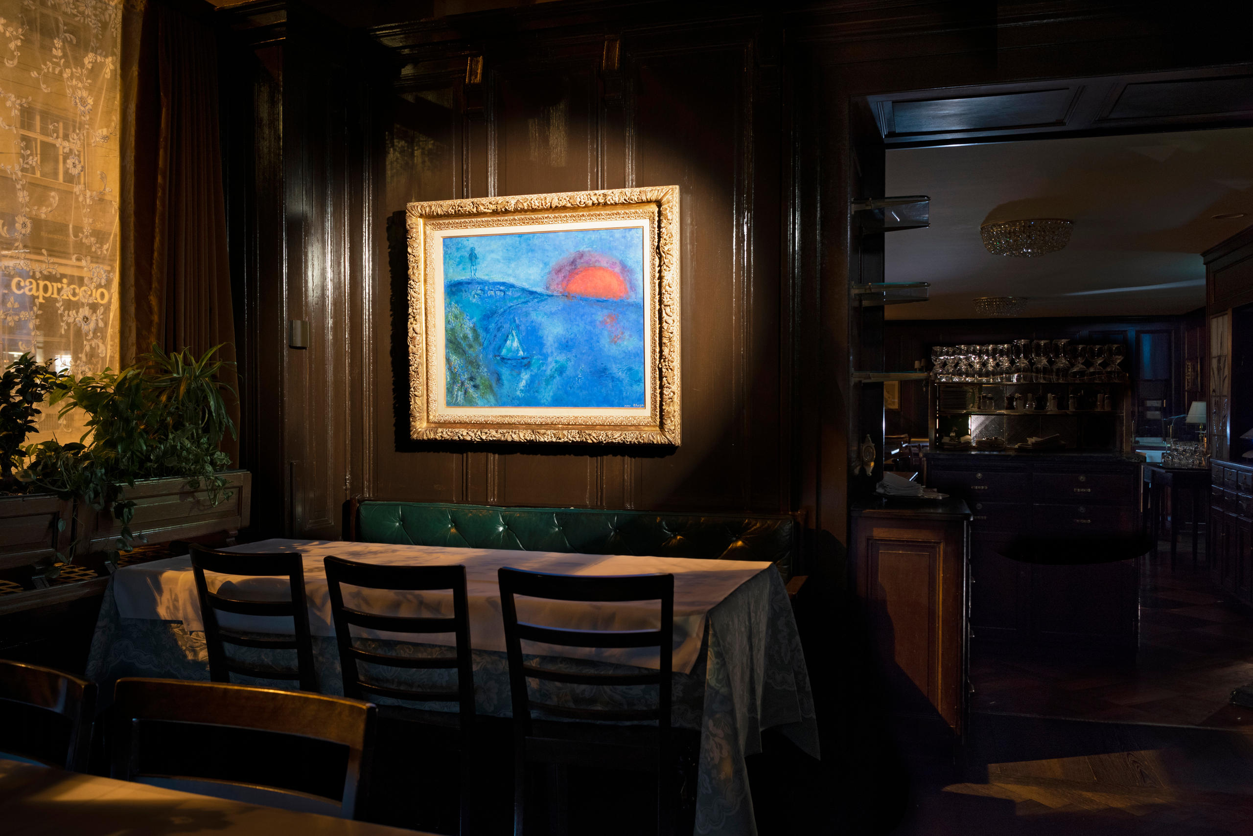 Une table dans un restaurant et, au-dessus, une peinture