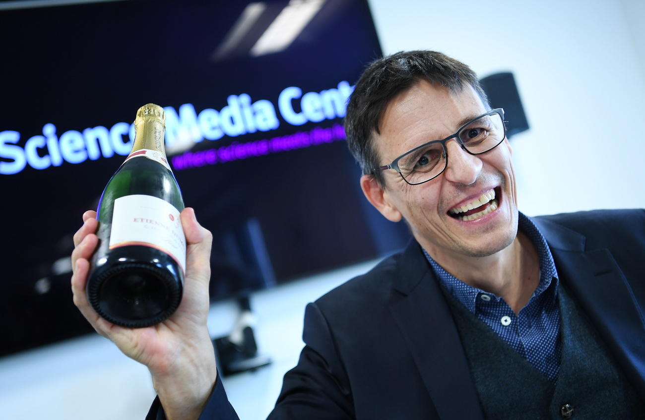 Swiss astrophysicist Didier Queloz with a bottle of champagne
