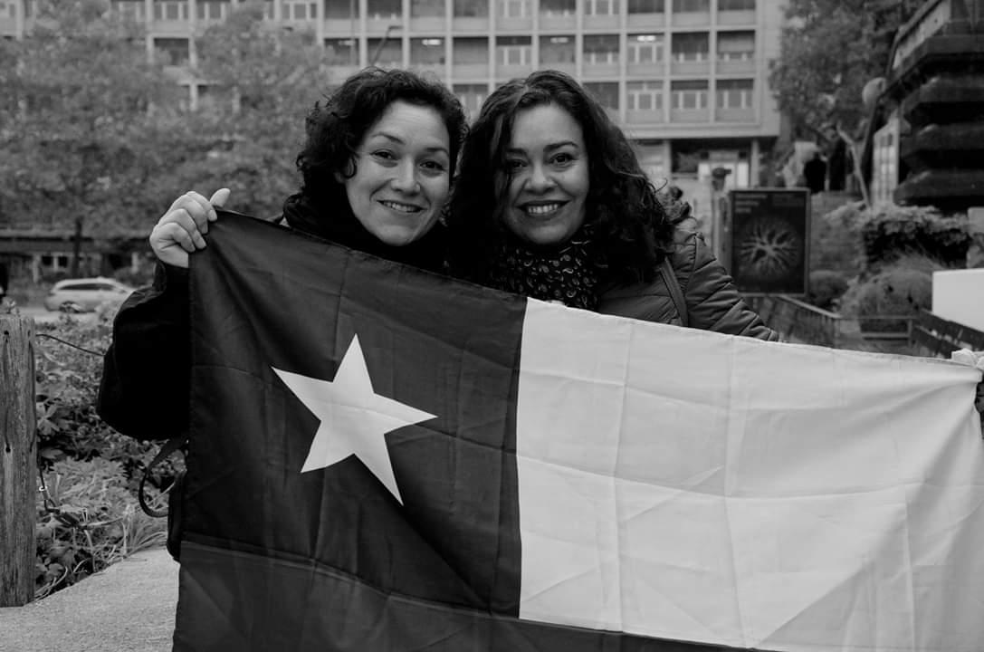 Dos chicas extienden una bandera de Chile