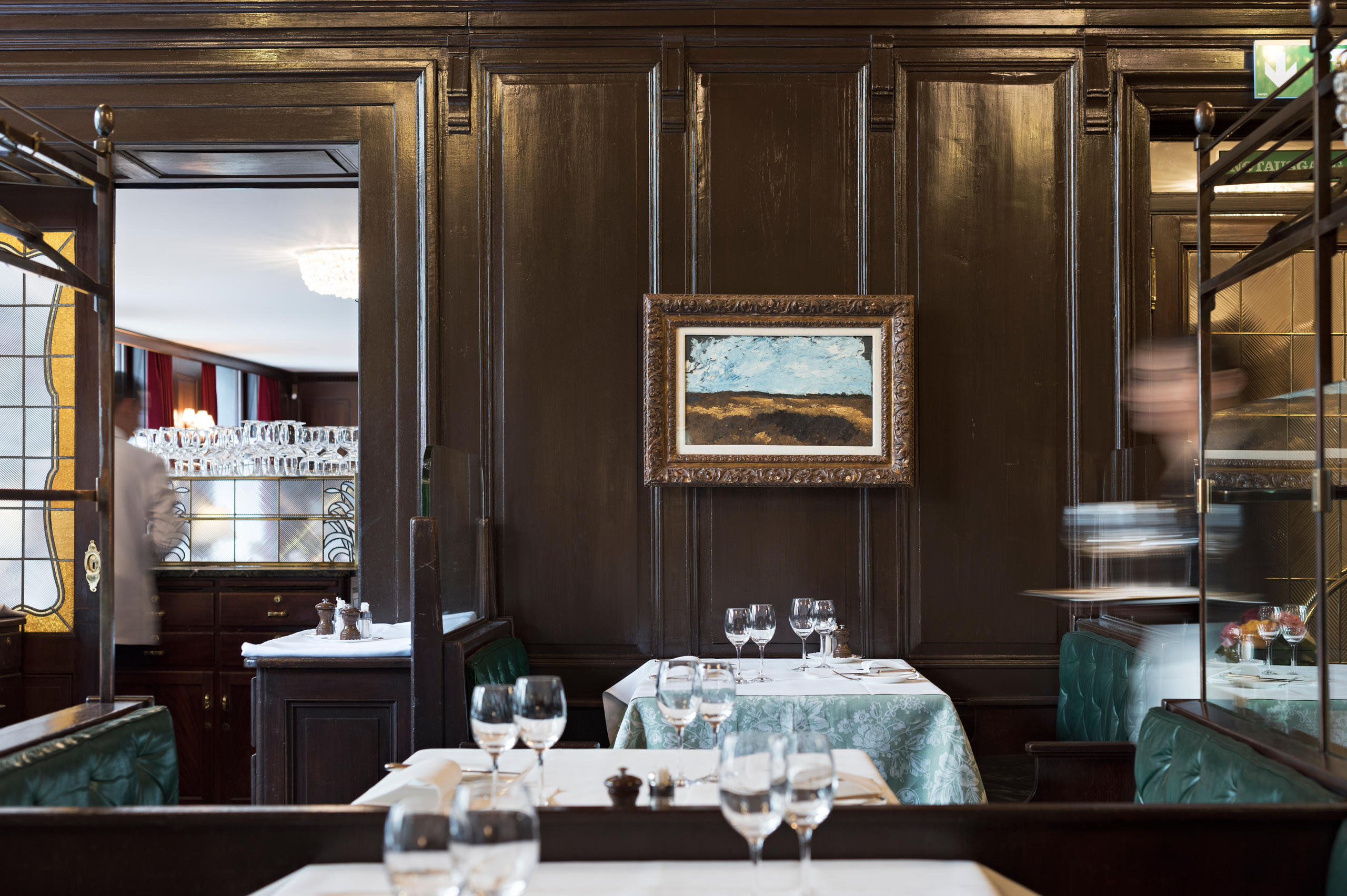 Une salle de restaurant avec une peinture au mur