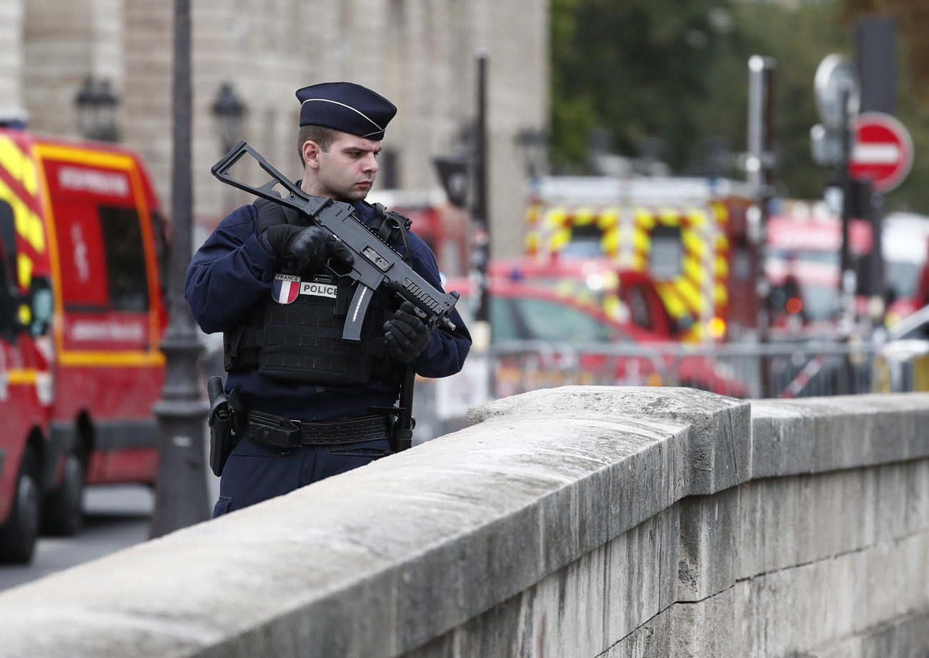 Poliziotto con mitra sul un ponte che porta all Ile -de-la-Cité dove è avvenuta la strage