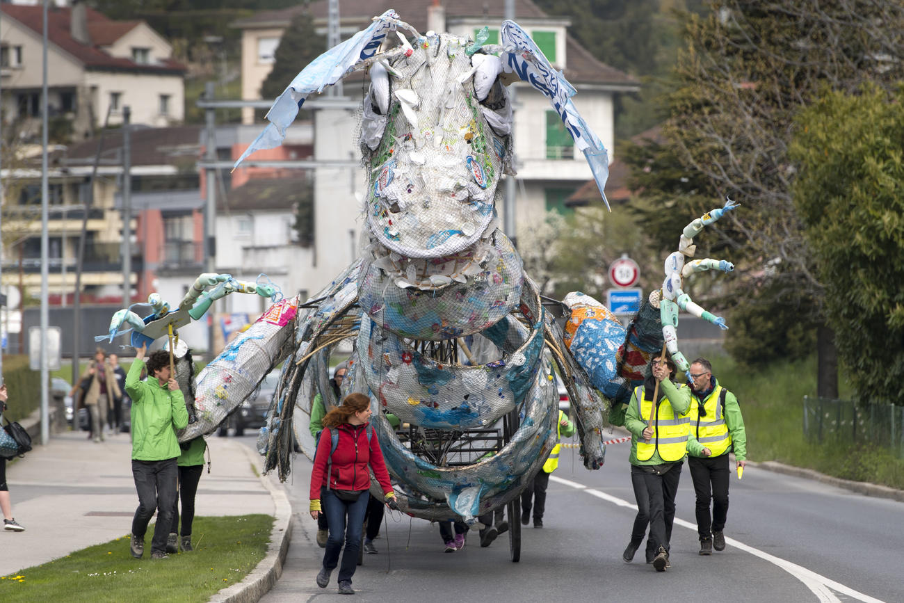 Greenpeace activists push a giant monster made of plastic waste toward Nestle headquarters in Vevey, Switzerland.