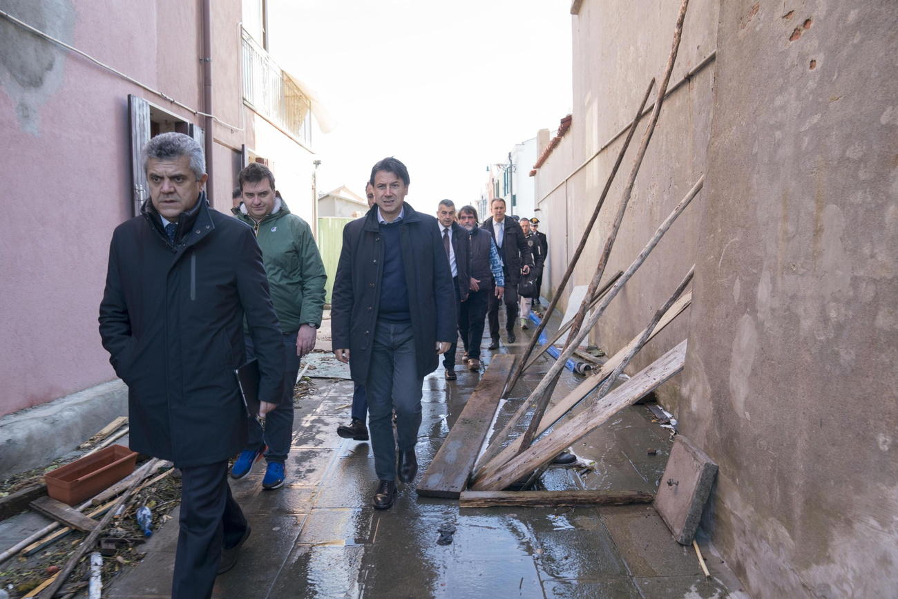 Il premier Giuseppe Conte in visita in una calla veneziana ostruita da assi e da fango.