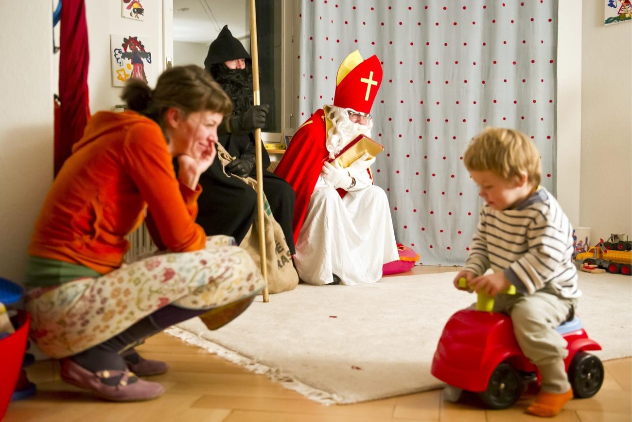 mãe e filho pequeno defronte um Samichlaus e Schmutzli