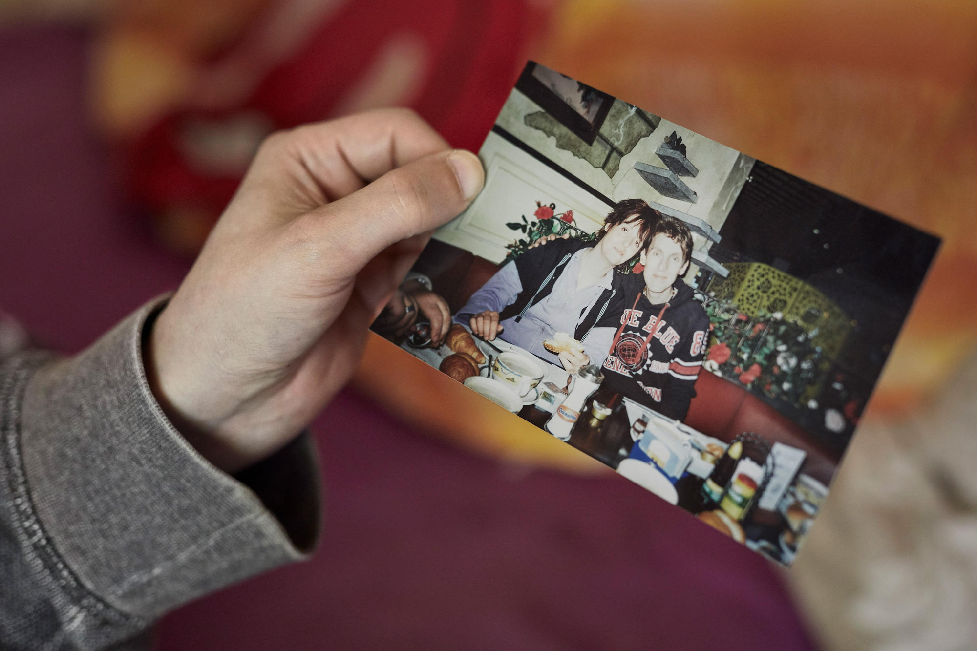 Hand die eine Foto mit jungem Paar zeigt