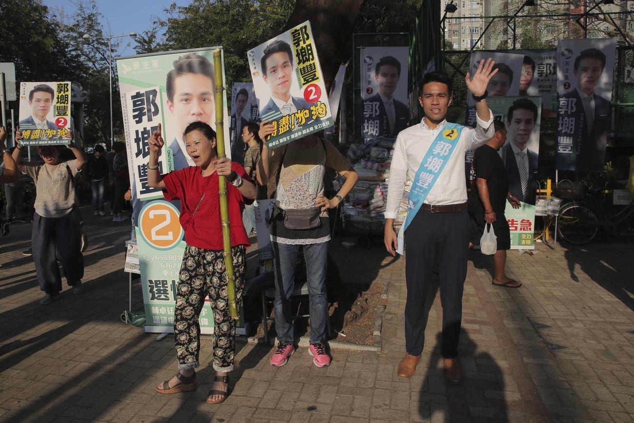 选举日当天，一位民主派候选人在街头与民众互动。