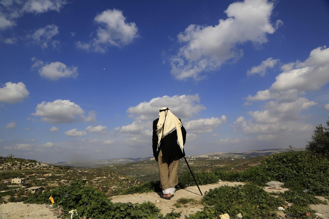 مواطن فلسطيني يرقب من بعيد أراضيه التي ستصادرها إسرائيل قريبا