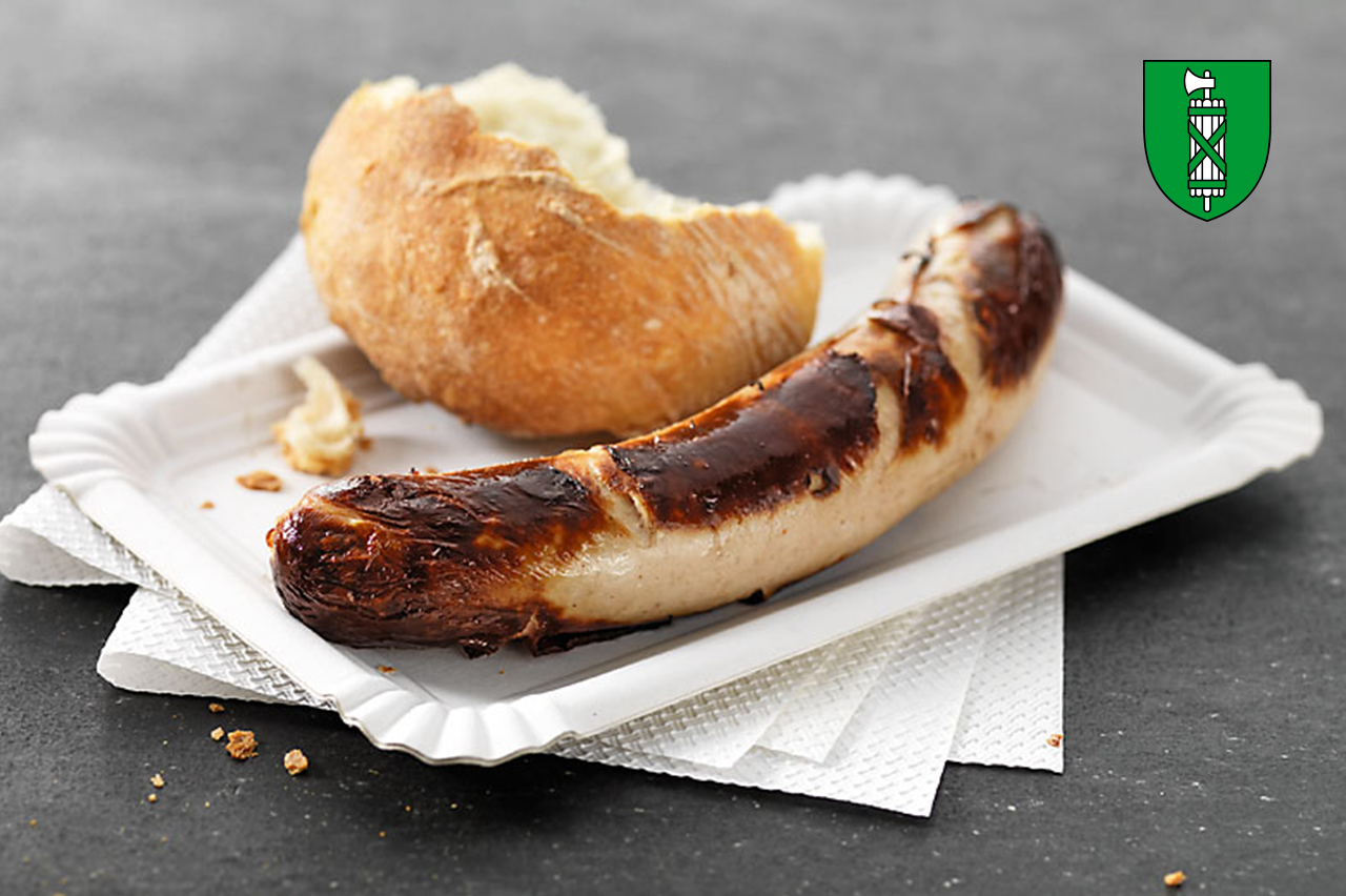 St. Galler Bratwurst mit Brot auf einem Kartonteller.