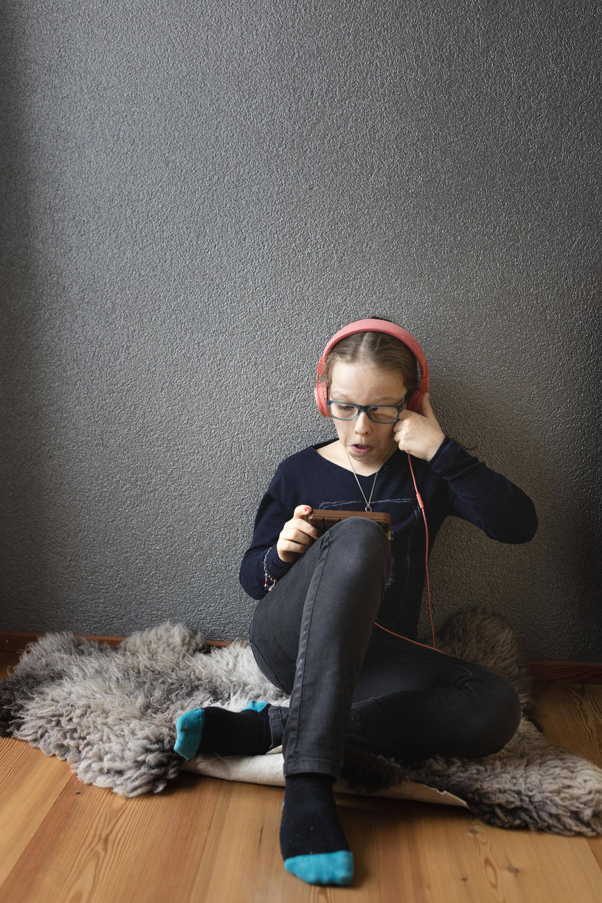 Young girl playing on her smartphone
