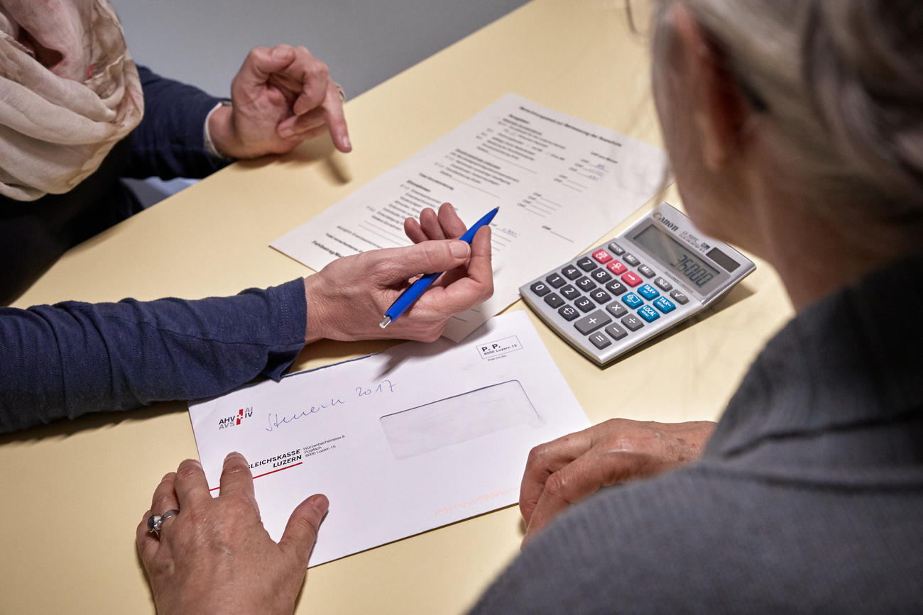 Dos personas mayores con un papel y una calculadora