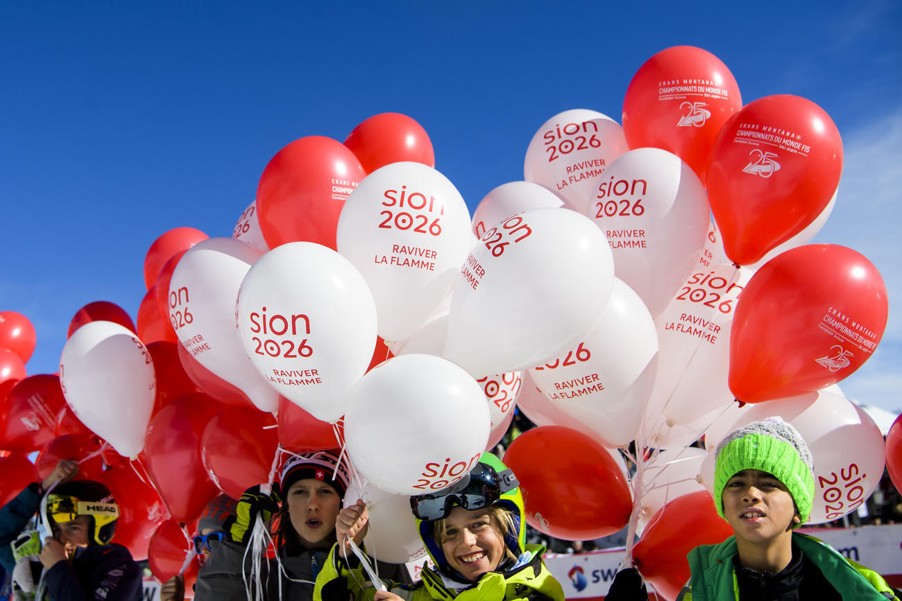 Children hold red and white Sion 2026 balloons