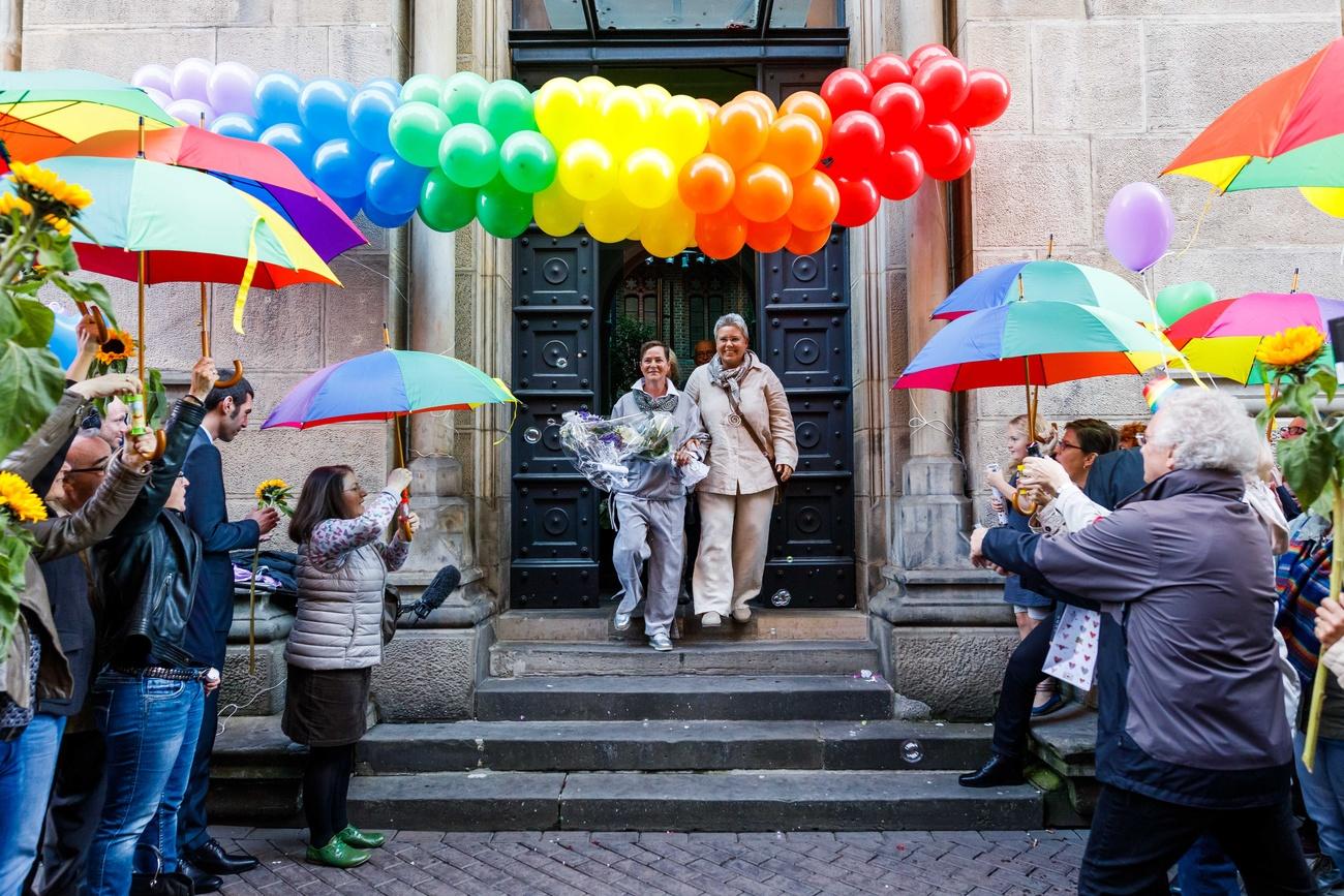 Una coppia gay festeggiata davanti a una chiesa.