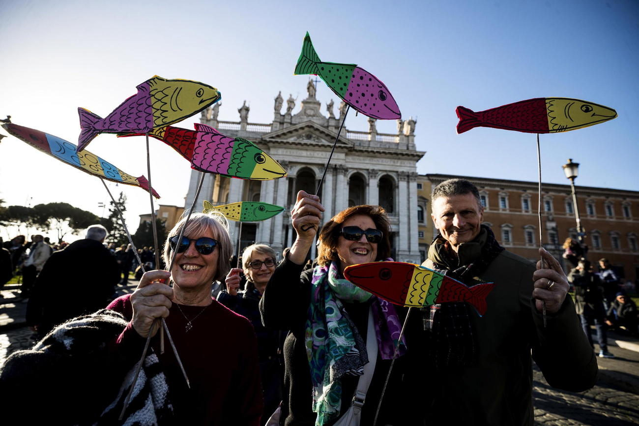 Manifestanti a Roma con in mano un pesce fatto di carta colorata