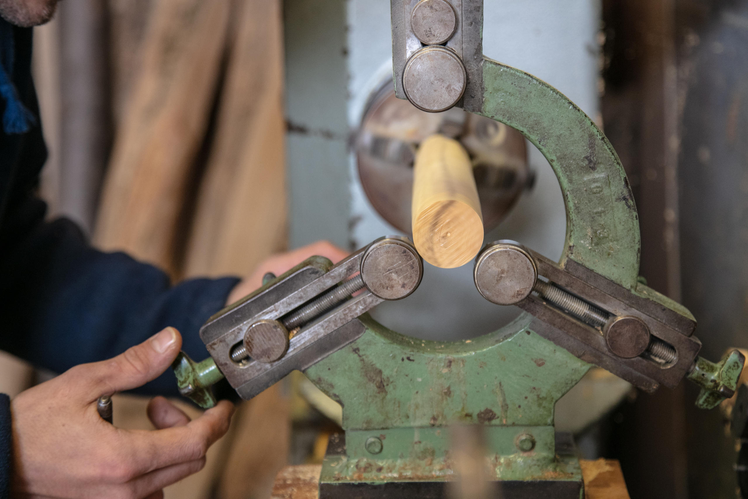 Joel inserisce il pezzo di legno in una speciale machcina